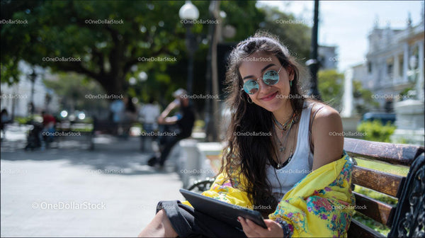 Stylish Young Woman Using Tablet in City Park on Sunny Day