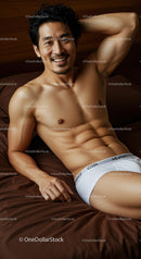 Smiling muscular man relaxing on bed in white briefs