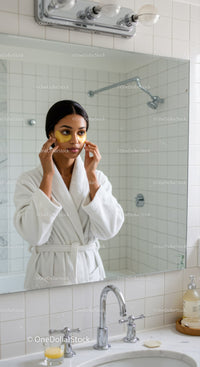 Woman applying under-eye patches in bathroom for skin rejuvenation