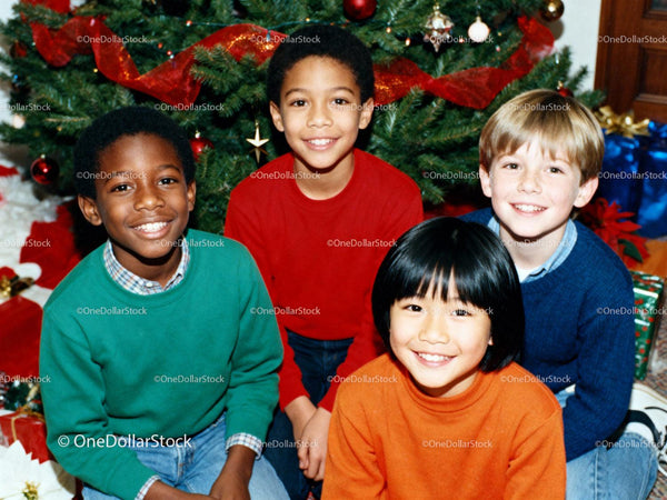 Four Children Smiling Together by Christmas Tree