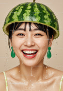 Joyful woman wearing watermelon helmet with water drops