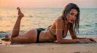 Seductive Woman in Black Bikini Relaxing on Beach During Sunset