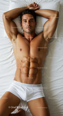 Relaxed muscular man lying on bed in white underwear