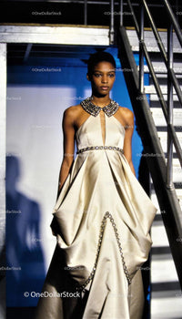 Elegant woman in beaded ivory evening gown by stairs
