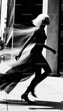 Elegant woman in black dress walking with flowing hair