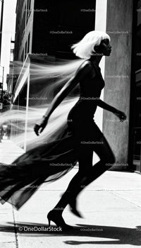 Elegant woman in black dress walking with flowing hair