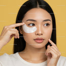 Young Woman Applying Eye Mask for Relaxation and Skin Care