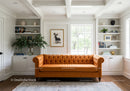 Cozy living room with vibrant orange tufted sofa