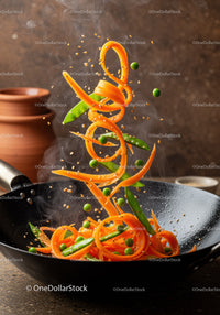 Fresh vegetables sizzling in black wok pan