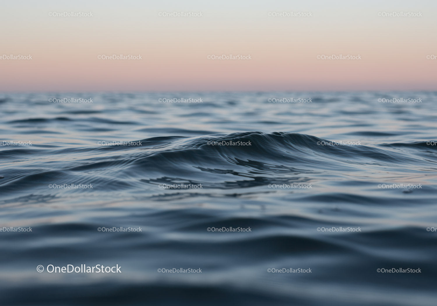 Spokojne fale oceanu o zachodzie słońca i pastelowym niebie