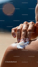 Applying moisturizing cream on sun-kissed shoulder