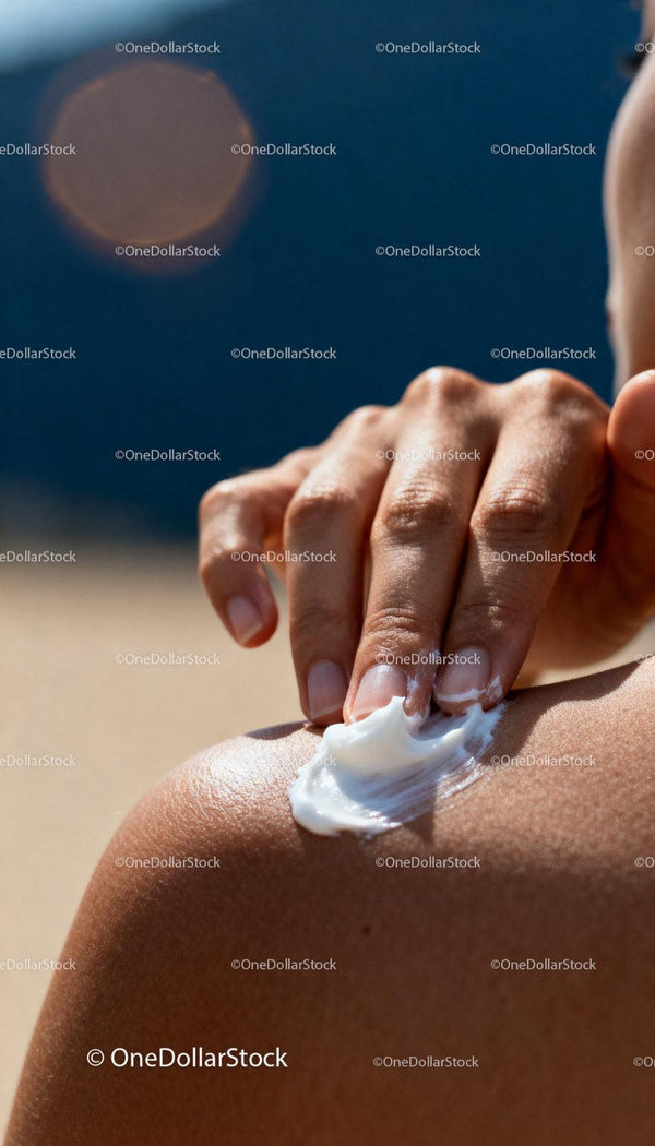 Applying moisturizing cream on sun-kissed shoulder