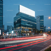 City street with illuminated billboard and light trails