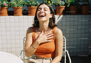 Joyful Woman Laughing Outdoors in Sunlight with Casual Style