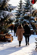 Couple walking through festive snowy Christmas market