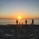 Silhouettes of a Family Enjoying Sunset on Sandy Beach at Dusk