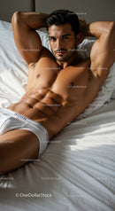 Athletic man relaxing on bed in white underwear