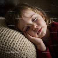 Peaceful little girl resting on cozy knitted pillow