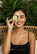 Young Woman Enjoying Facial Mask with Cucumber Slice in Spa Setting
