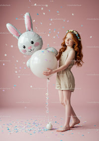 Girl holding bunny balloon with confetti celebration