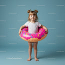 Little girl with inflatable donut swim ring on blue