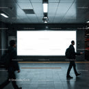 People walking past empty subway advertisement board