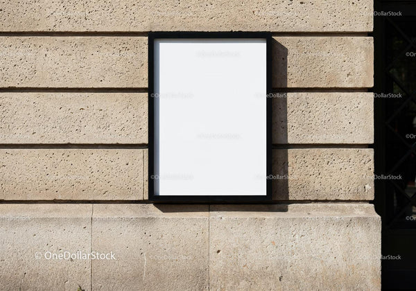 Blank poster with black frame on textured stone wall JPG Mockup Image