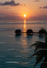 Beautiful Sunset Over Tropical Ocean With Overwater Bavilions and Reflection