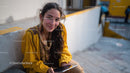 Young Woman Smiling while Using Smartphone in City Street