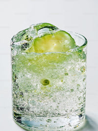 Refreshing sparkling water with cucumber slice closeup
