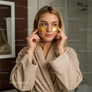 Young Woman Applying Under Eye Gel Patches in Bathroom