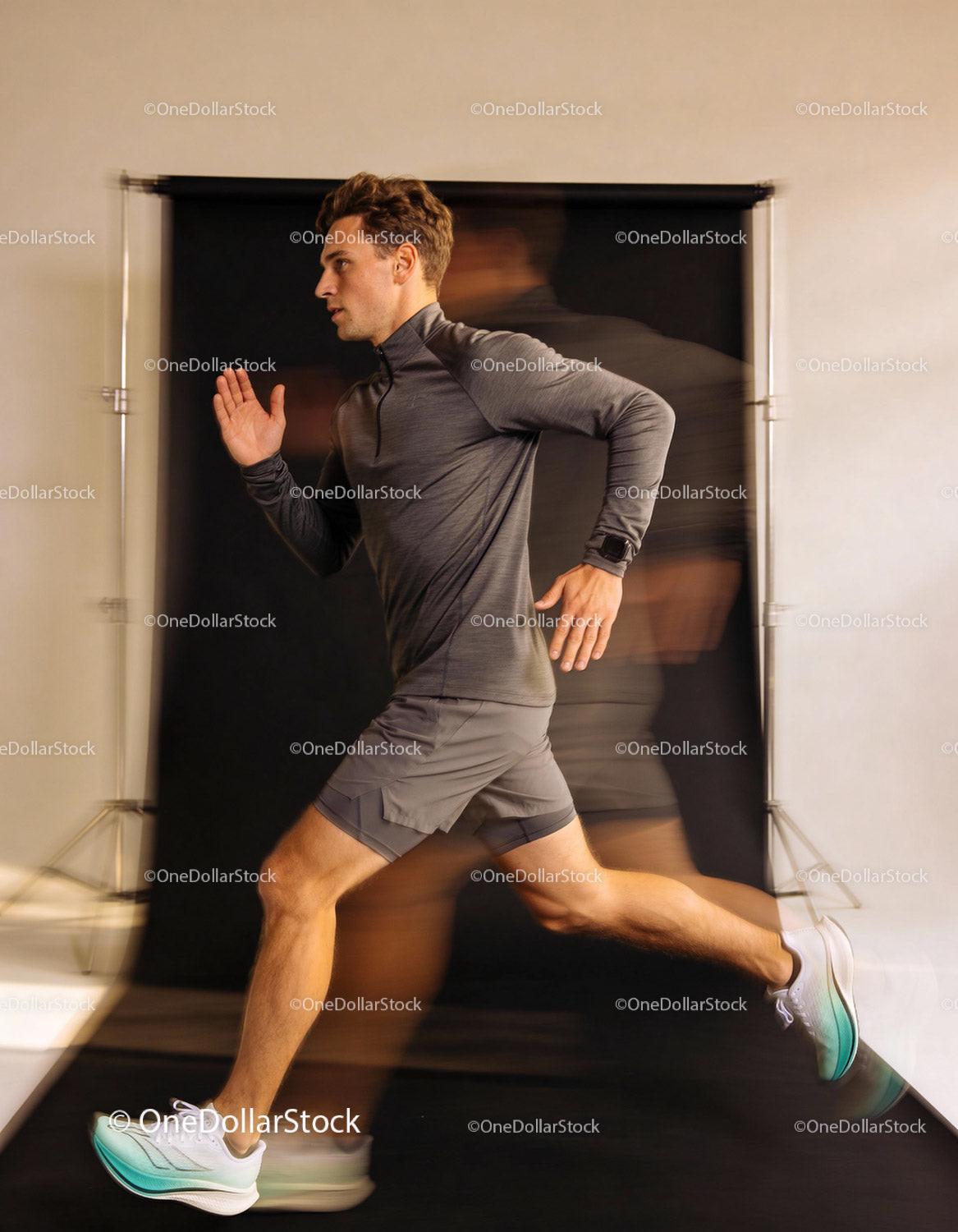 Young man running fast in sportswear studio shot