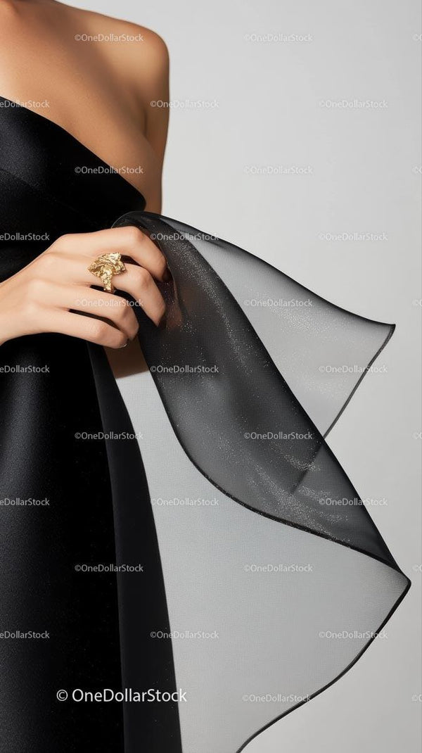 Elegancka kobieta w czarnej sukience z przezroczystą tkaniną, biżuterią i stylem