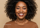 Portrait of a Smiling Woman with Curly Hair Wearing Hoops in Casual Style