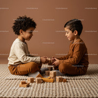 Two happy boys building wooden blocks together indoors