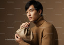 Portrait of a Young Man in Brown Turtleneck with Beige Bag in Studio
