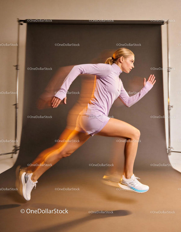 Focused female athlete sprinting indoors with dynamic motion