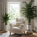 Elegant indoor beige armchair with lush houseplants by large window