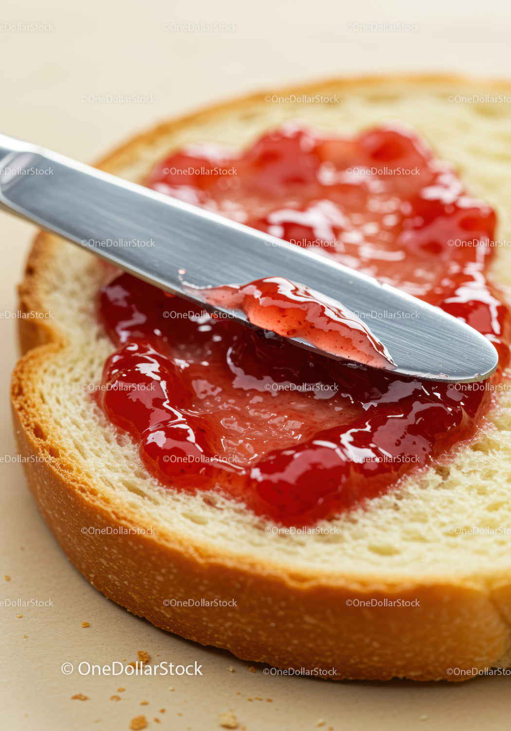 Fresh bread slice with strawberry jam and butter knife