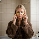 Young Woman Applying Gold Eye Masks for Skincare Relaxation