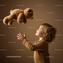 Curious toddler reaching for floating teddy bear