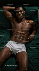 Smiling young man relaxing in white underwear on bed