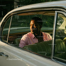 Young Man Sitting in Vintage Car Interior with Sunlight