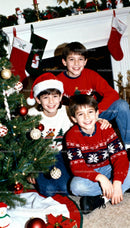 Three boys enjoying Christmas by decorated tree