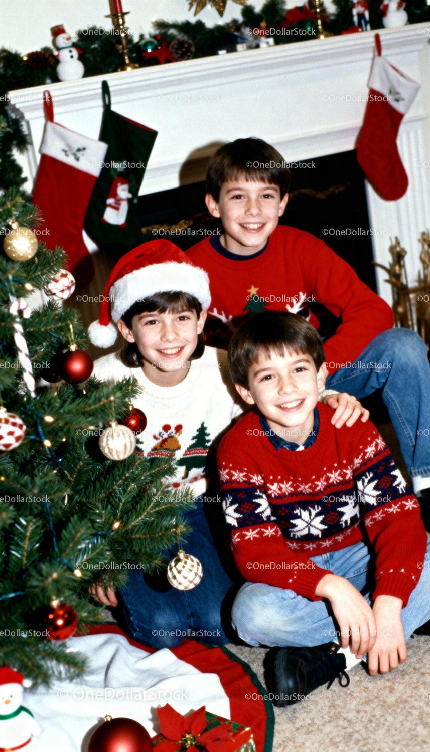 Three boys enjoying Christmas by decorated tree