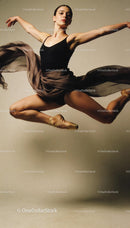 Graceful ballet dancer leaping in midair with flowing skirt