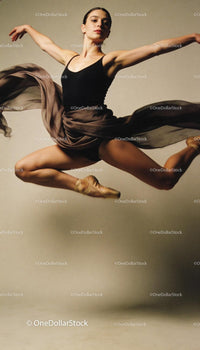 Graceful ballet dancer leaping in midair with flowing skirt