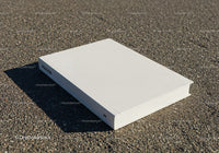 Minimalist white book on textured asphalt surface