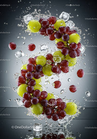 Fresh red and green grapes splashing with ice cubes