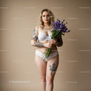 Elegant Tattooed Woman Holding Purple Flowers in White Lingerie